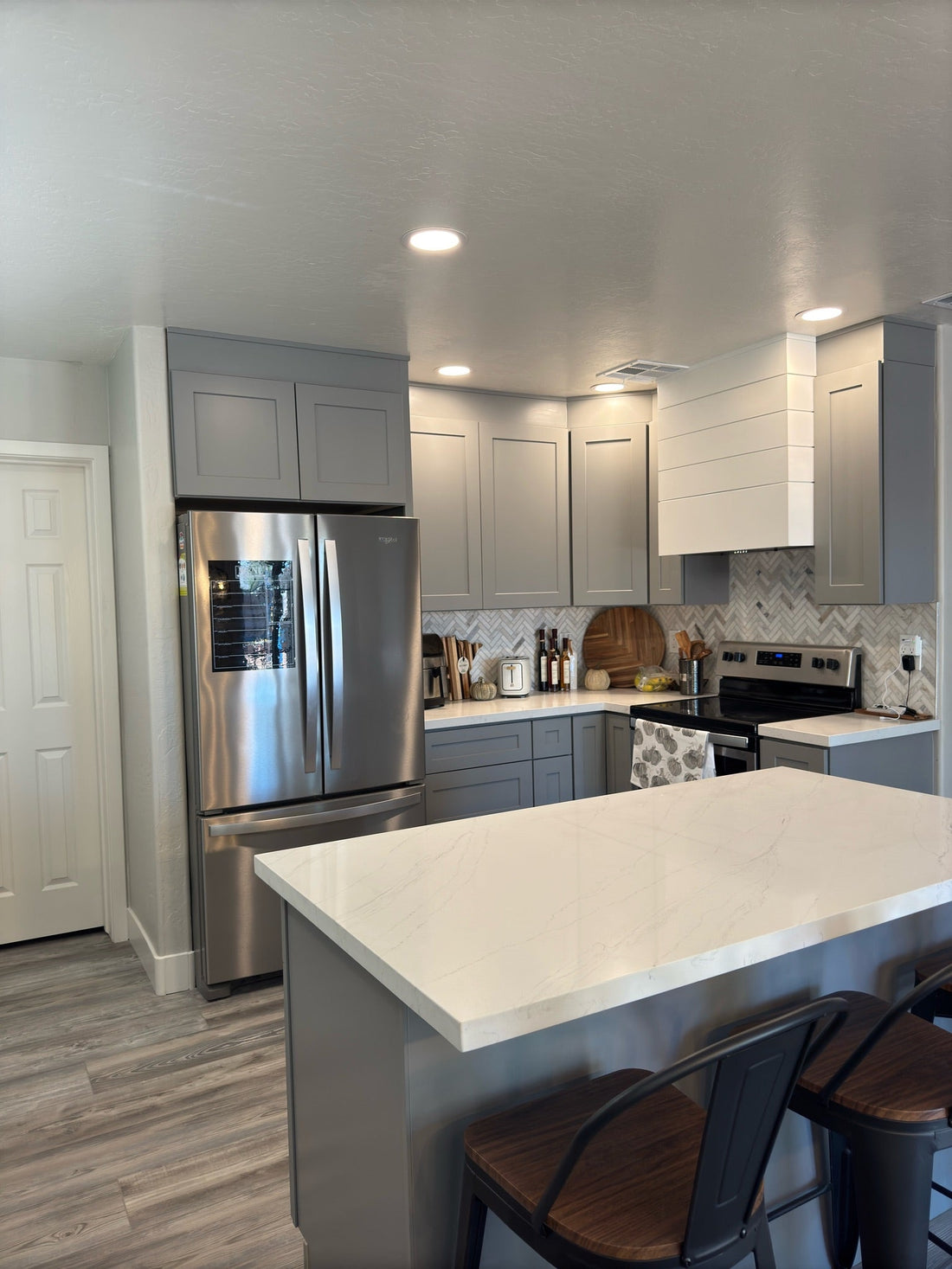 Gray shaker kitchen cabinets and custom white range hood during Surprise AZ kitchen remodel