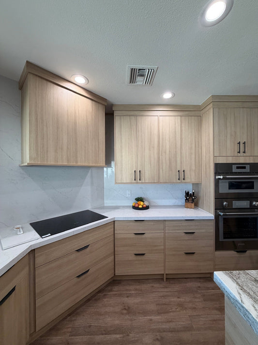 European-style kitchen remodel in Mesa AZ with light wood custom cabinets, quartz countertops and backsplash, and built-in double ovens